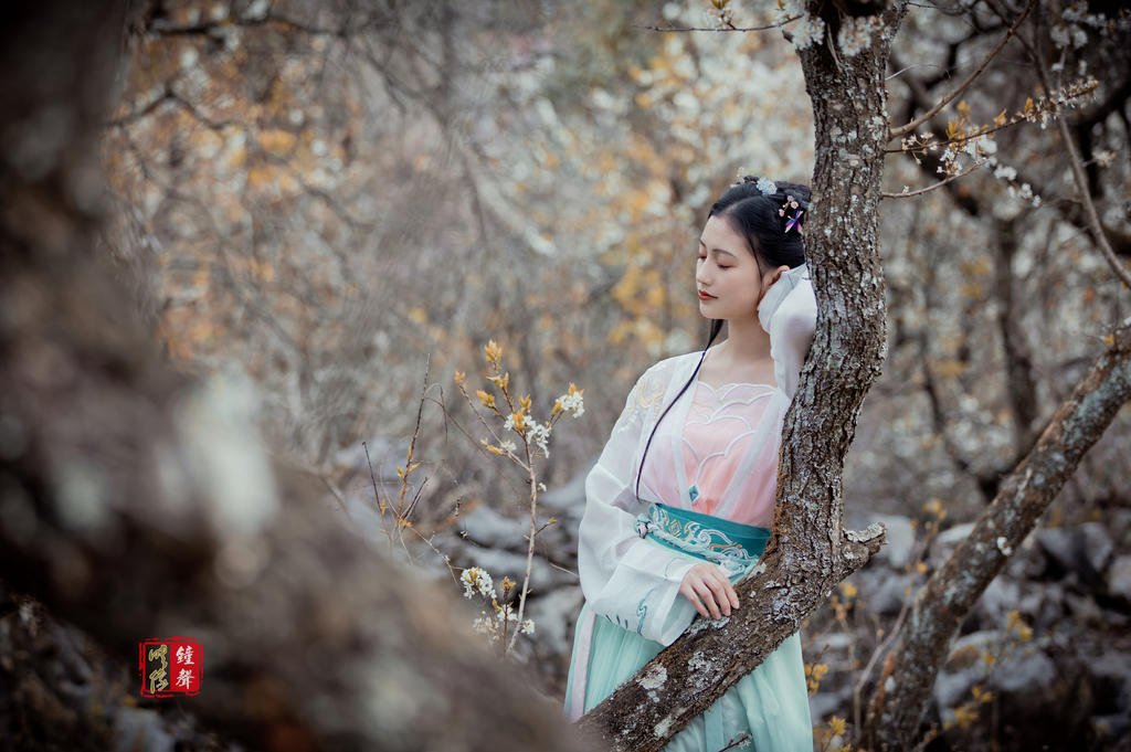 古装美女手执罗扇漫步花林美图