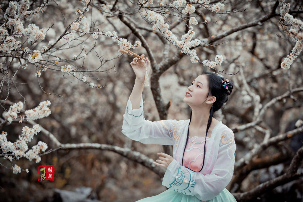 古装美女手执罗扇漫步花林美图