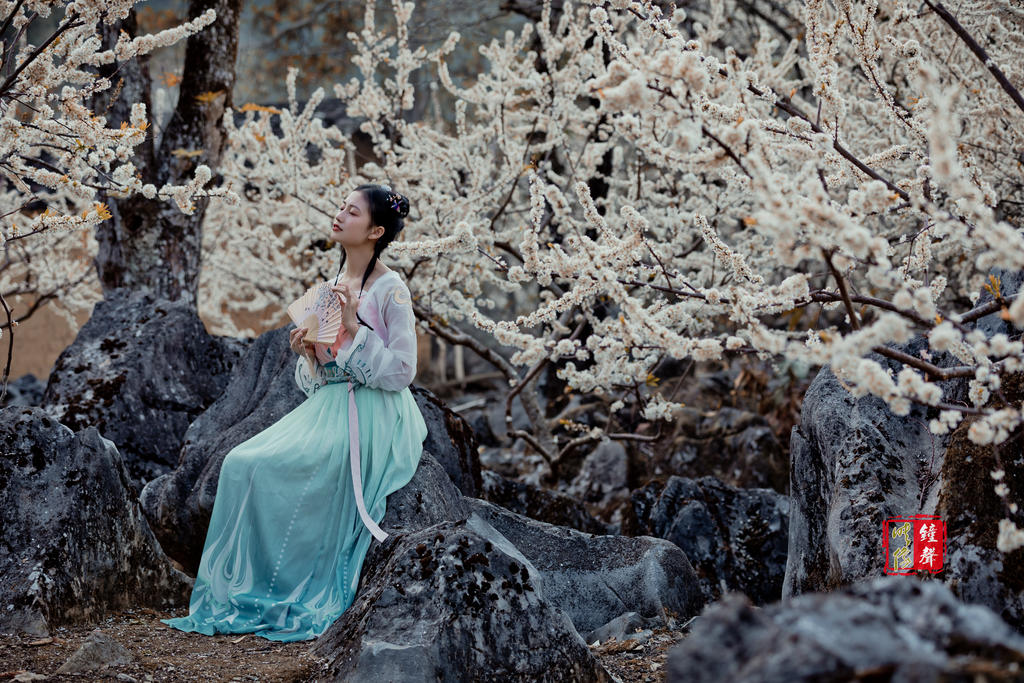 古装美女手执罗扇漫步花林美图